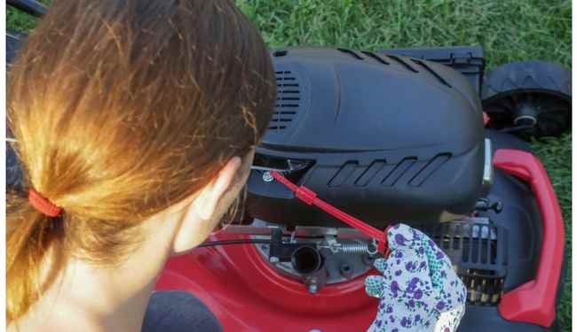 Woman checking oil in lawn mower